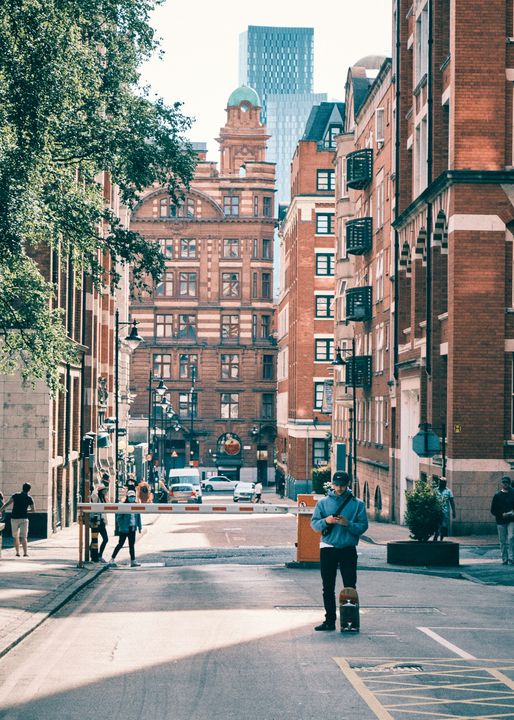 People walking past a brick building in Manchester